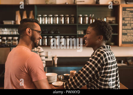 Lächelnde junge Paar Kaffee zusammen bestellen In einem Café Stockfoto