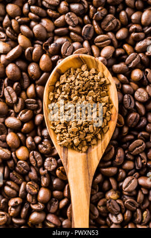 Die Instant Kaffee und Kaffeebohnen in Löffel aus Holz. Stockfoto