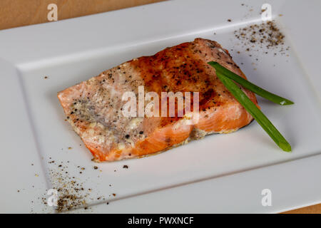 Gebratenes Lachssteak serviert grüne Zwiebel Stockfoto