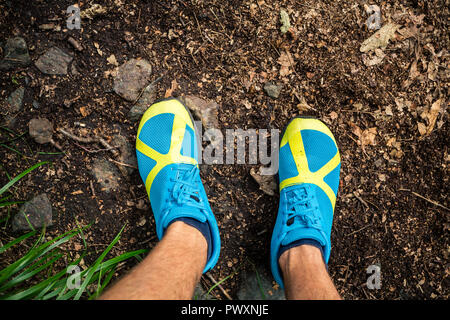 Trail Runner suchen nach unten am Sport Schuh, Running und Training in der Natur. Mann Runner, draußen in der Natur. Stockfoto