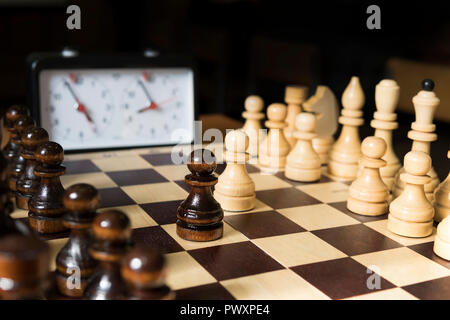 Schachspiel auf dem Schachbrett. Mit selektiver Fokus auf weißen pieses. auf dunklem Hintergrund Stockfoto