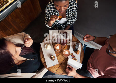 Freunde in einem Café Tisch köstliche Desserts sitzen zusammen Stockfoto