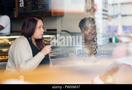 Diverse junge Freunde zusammen gesprochen in einem Cafe Stockfoto