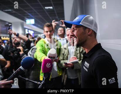 Frankfurt am Main, Deutschland. Okt, 2018 18. Patrick Lange, Ironman World Champion 2018, wird von Vertretern der Medien an der Rezeption interviewt. Vorjahressieger und aktuelle Ironman Weltmeister Patrick Lange wird von Verwandten, Fans und Medien bei Rheinmain Flughafen empfangen werden. Lange war die erste Person, der Ironman auf Hawaii unter acht Stunden zu meistern. Credit: Andreas Arnold/dpa/Alamy leben Nachrichten Stockfoto