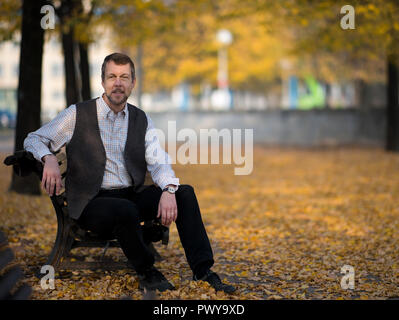 Dresden, Deutschland. Okt, 2018 18. Oper Sänger Georg Zeppenfeld sitzt auf einer Bank am Ufer der Elbe. Die international renommierte Bass wird die Semperoper Foundation Prize am 21. Oktober 2018 erhalten. Credit: Monika Skolimowska/dpa-Zentralbild/dpa/Alamy leben Nachrichten Stockfoto