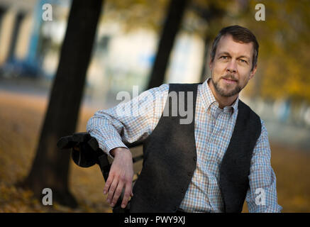 Dresden, Deutschland. Okt, 2018 18. Oper Sänger Georg Zeppenfeld sitzt auf einer Bank am Ufer der Elbe. Die international renommierte Bass wird die Semperoper Foundation Prize am 21. Oktober 2018 erhalten. Credit: Monika Skolimowska/dpa-Zentralbild/dpa/Alamy leben Nachrichten Stockfoto