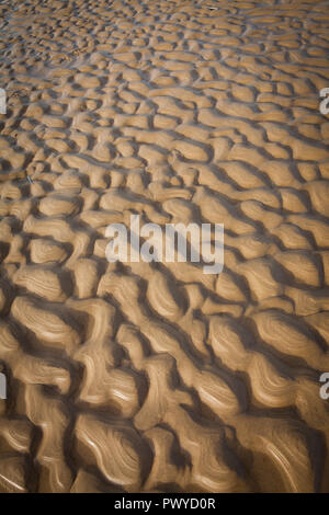 Wellen am Strand durch die abziehenden Flut links Stockfoto