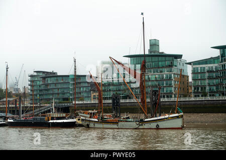 Die alte Thames Barge wird im Hermitage Gemeinschaft Moorings auf der Themse mit Luxus Riverside Apartments London England UK Günstig Stockfoto