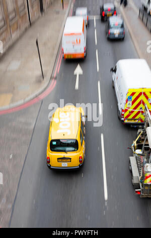 London, Großbritannien. Ein gelbes Taxi ist von oben vorbei unter einer Brücke aus gesehen. Stockfoto