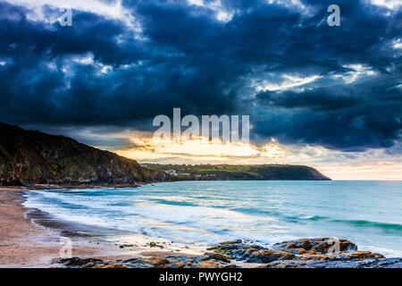 Sonnenuntergang über dem Strand von Tresaith, Ceredigion, Wales, in Richtung Aberporth. Stockfoto