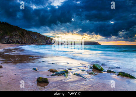 Sonnenuntergang über dem Strand von Tresaith, Ceredigion, Wales, in Richtung Aberporth. Stockfoto