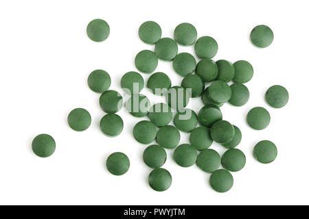 Haufen von Spirulina Tabletten Algen Nahrungsergänzung auf weißem Hintergrund Nahaufnahme, Ansicht von oben isoliert. Flach. Stockfoto