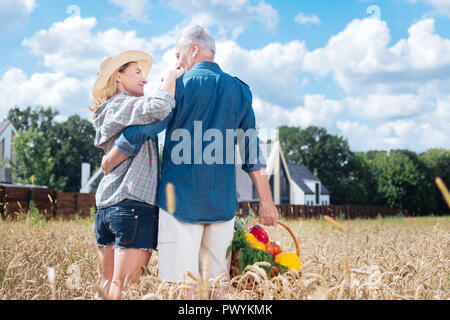 Pflege liebevolle Mann an seine schöne stilvolle strahlende Frau suchen Stockfoto