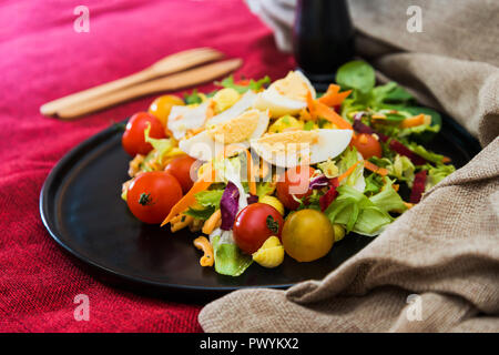 Frischer Salat - lecker frischer Salat mit Tomaten, Salat, Aubergine, Zucchini, Käse, Parmaschinken und Olivenöl. Stockfoto