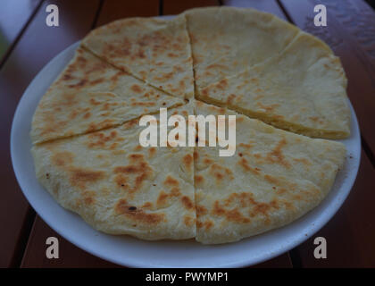 Traditionelle georgische Khachapuri Imeruli gefüllt mit Käse auf einer Platte Stockfoto