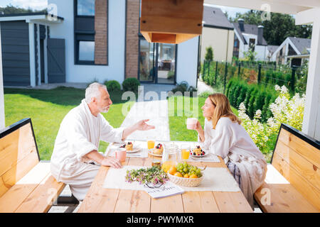 Reifen übertragen von Frau und Mann tragen weiße Bademäntel Frühstück Stockfoto