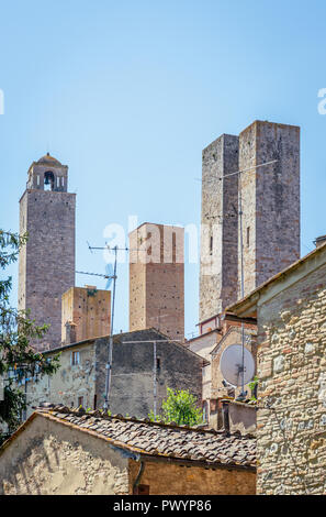 Vertikale Foto mit Blick auf den sehr berühmten, alten angestammten Familie Türme in UNESCO-Stadt San Gimignano. Die Aussicht ist über mehrere Dächer aus Stein und Stockfoto