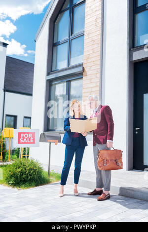 Unternehmer tragen stilvoll eleganten Anzug Dokumente prüfen beim Kauf Haus Stockfoto