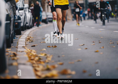 Marathon Rennen, Menschen die Füße auf Herbst Straße. Läufer laufen Marathon in der Stadt die Stadt. Gruppe aktiver Menschen läuft Marathon Rennen in der Cit Stockfoto