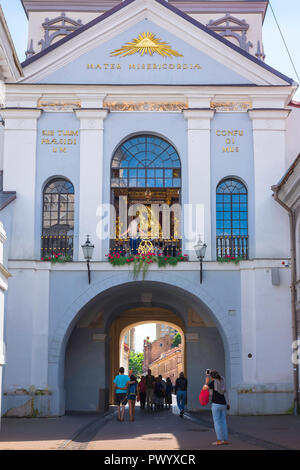 Kapelle der Tor der Morgenröte, in die Altstadt von Vilnius eine Frau nimmt ein Foto von Menschen, die in der Kapelle und Heiligtum der Madonna im Tor der Morgenröte. Stockfoto