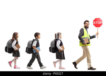 Volle Länge Profil Aufnahme von Schülern zu Fuß hinter einen Lehrer mit einer Warnweste und ein Stop-Schild auf weißem Hintergrund Stockfoto