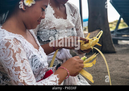 PEMUTERAN, BALI - Januar 2018: Eine Gruppe von Frauen in Bali, Indonesien die Vorbereitung der täglichen Angebote mit Lebensmittel und Blumen Stockfoto