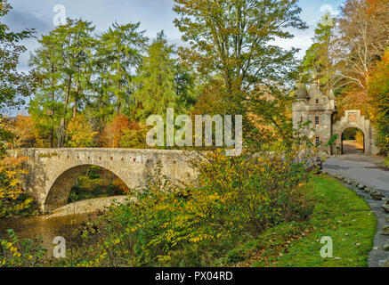 Alte Brücke von AVON BALLINDALLOCH CASTLE GRAMPIAN SCHOTTLAND DIE BRÜCKE UND HERRSCHAFTLICHE TORHAUS mit HERBSTLAUB UND FARBE Stockfoto