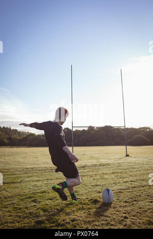 Rugby Spieler kicken Rugby Ball in das Feld Stockfoto