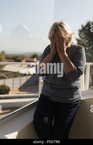 Frau, die ihr Gesicht auf der Terrasse Stockfoto