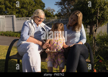 Multi-Generation, Familie, bei Foto Album im Garten Stockfoto