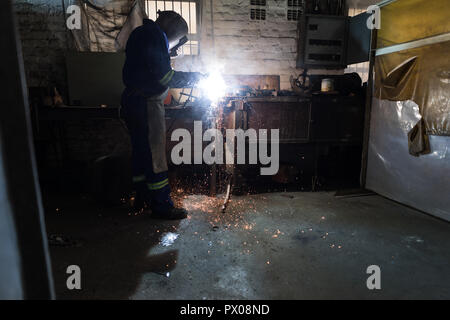 Schmied mit einem Schweißbrenner in Werkstatt Stockfoto