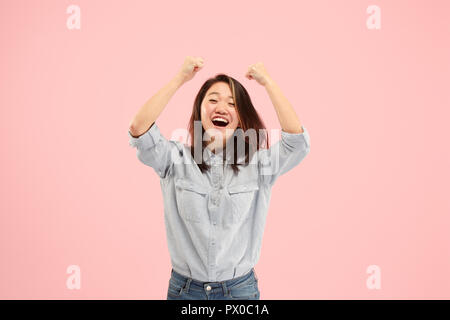 Ich gewann. Gewinnen Erfolg glücklich Frau feiert sein ein Sieger. Dynamisches Bild der kaukasischen weibliche model in Pink Studio Hintergrund. Sieg, Freude Konzept. Menschlichen gesichts Emotionen Konzept. Trendige Farben Stockfoto