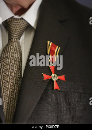 Details der Mann hält ein Kreuz des Verdienstordens der Bundesrepublik Deutschland in einer Rede Stockfoto