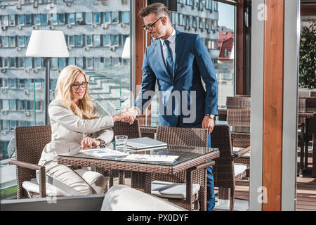 Geschäftspartner Begrüßung mit Händedruck im Cafe Stockfoto
