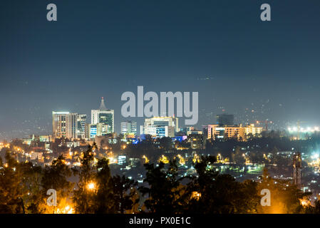 Einen weiten Blick über die Skyline der Stadt Kigali nachts beleuchtet, unter einem tiefblauen Himmel mit dem Schein der Straßenlaternen in t Stockfoto