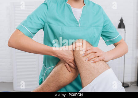 7/8 Schuß von Massage Therapeut tun Bein Massage an Patienten in der Klinik Stockfoto