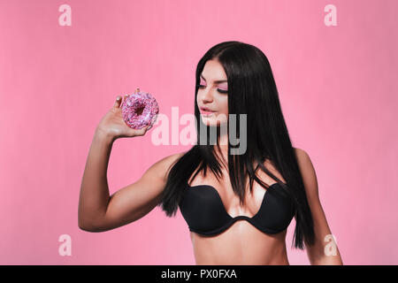 Beauty fashion model Mädchen unter bunten Donuts Stockfoto