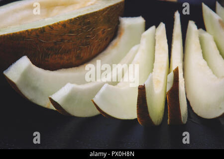 Aufgeschnittene melone Schichten auf schwarzem Hintergrund Stockfoto