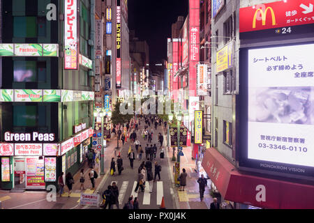 Ein Abend in der Nähe des geschäftigen Bahnhofs Shinjuku, mit Leuchtreklamen, Einkaufsviertel, neon Plakate, und die Menschen auf der Straße. Stockfoto