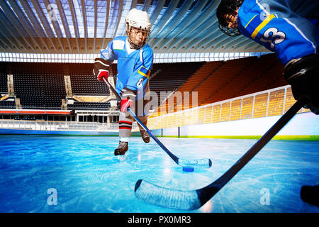 Hockey Spieler anspruchsvolle für Kobold auf Eisbahn Stockfoto