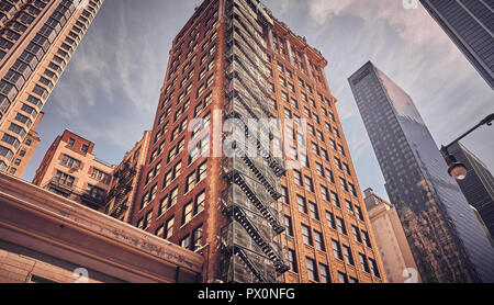 Blick auf alte Gebäude in Manhattan bei Sonnenuntergang, Retro filmische Tonen angewendet, New York, USA. Stockfoto