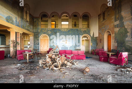 Innenansicht der ein Zimmer in einem verlassenen Disco mit einer Lampe auf den Boden und roten Sofas, in Italien. Stockfoto