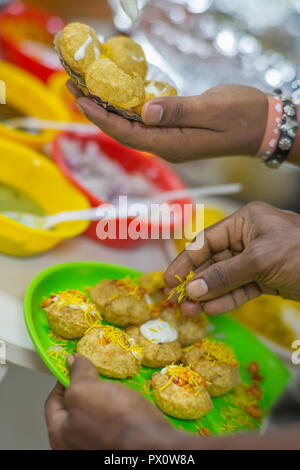 Hände garnieren pani Puri, einer traditionellen indischen Imbiss. Stockfoto