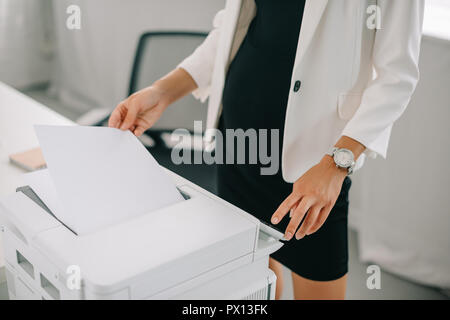 Teilansicht der schwangeren Unternehmerin mit Drucker im Büro Stockfoto