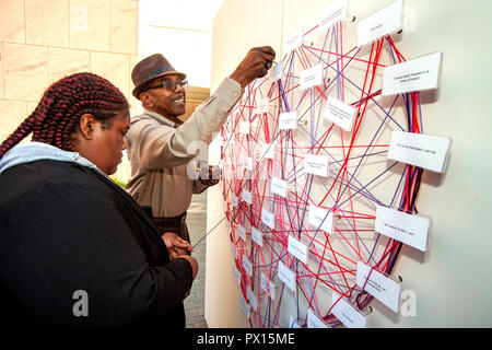 Verschiedene Farben von Garn sind rund um Zitate von Martin Luther King jr. bei einem Projekt in Costa Mesa, CA, inspiriert von King's Aussage, dass "Wir unentrinnbar in einem Netzwerk von Gegenseitigkeit gefangen, Krawatten in einem einzigen Kleidungsstück des Schicksals gewunden sind. Was auch immer man direkt betrifft, betrifft alle direkt." Stockfoto