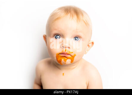 Ein Adorable Baby Mädchen, ein Durcheinander, während sich die Fütterung Stockfoto