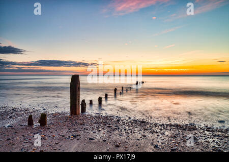 Bleibt der buhnen am Strand von Sandsend, Whitby, North Yorkshire, in der Dämmerung Stockfoto