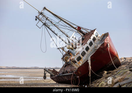 Einen verlassenen baufälligen Fischerboot auf einem Felsen Jetty gestrandet. Stockfoto