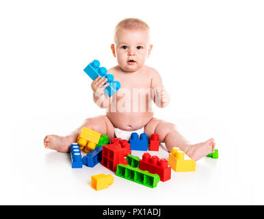 Baby Boy spielt mit Spielzeug Bausteine auf weißem Hintergrund Stockfoto