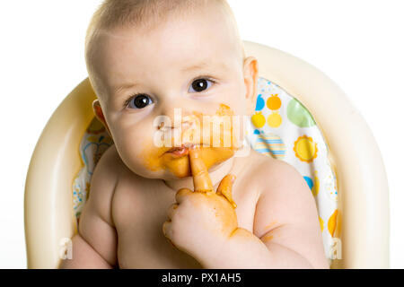 Baby essen ihr Abendessen Spaghetti und ein Chaos auf seinem Gesicht Stockfoto